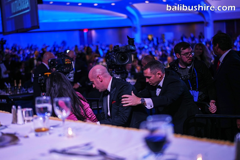 Katie Miller and Stephen Miller are escorted out after an incident at the annual White House Correspondents' Association Dinner on Saturday in Washington, DC.